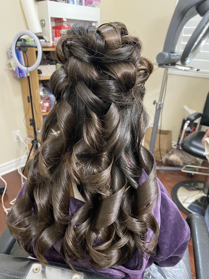 Half up style with large curls on dark hair, seen from behind